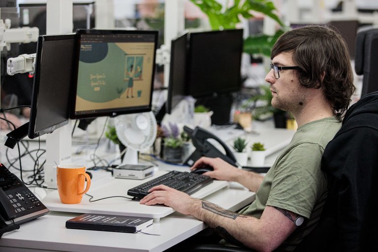 A man sat at his computer, designing a website design